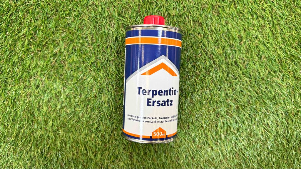 Der getestete Terpentinersatz in der 500-ml-Dose liegt auf einem grünen Kunstrasen.