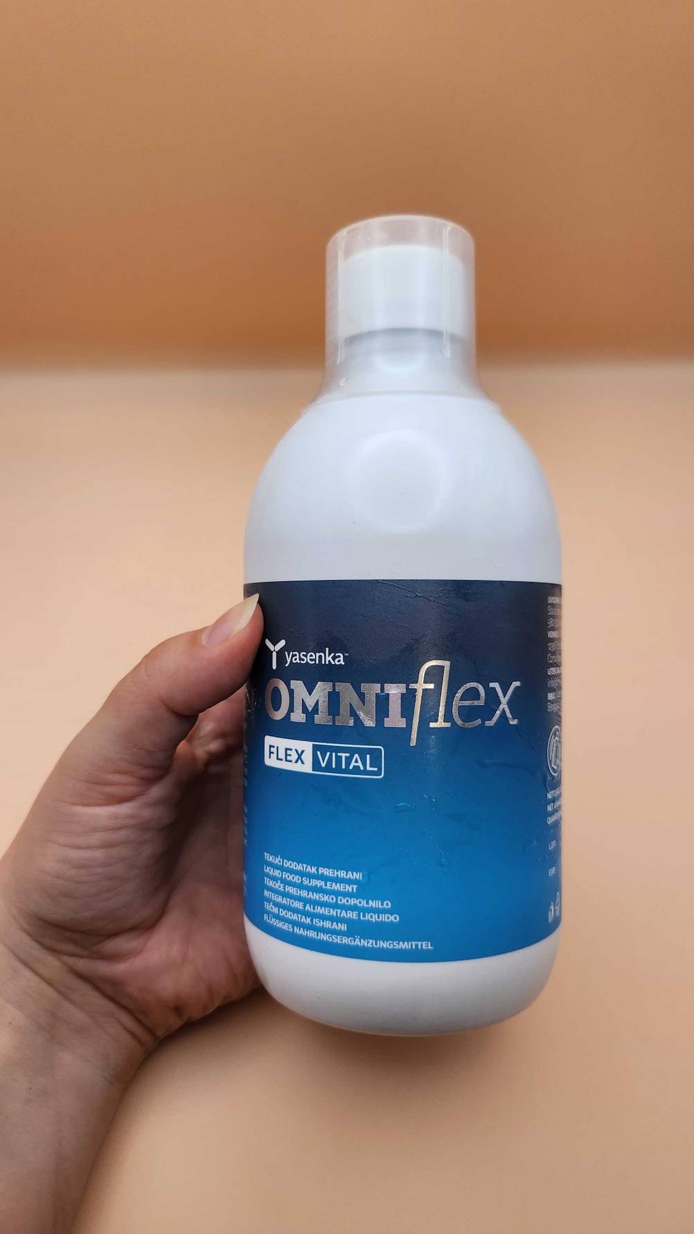 Ein Hand hält das flüssige Kollagen in einer Flasche.