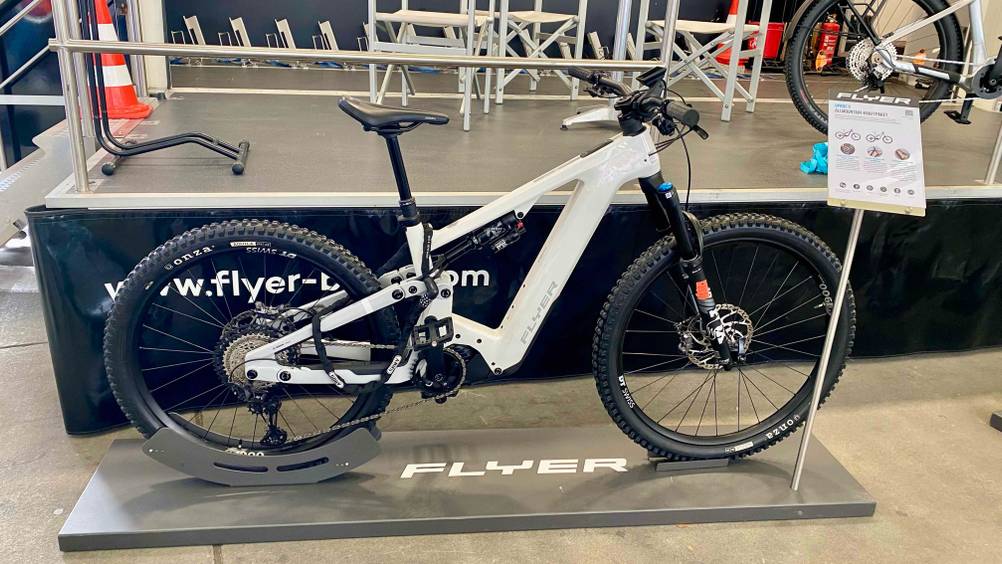 Im Test: Ein Elektro-Mountainbike von der Seite auf einem Ständer mit Informationstafel daneben.