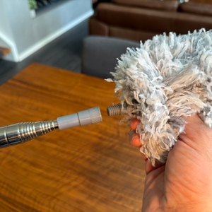 Eine Hand schraubt den Griff auf den Fogray-Staubwedel.