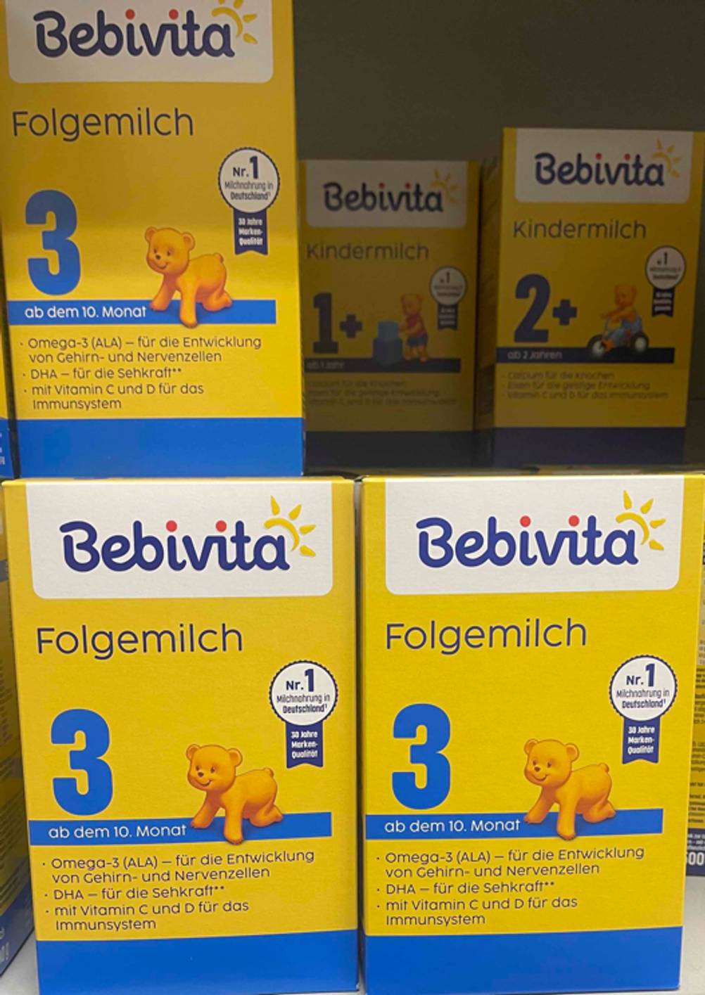 Folgemilch 3 im Test: Mehrere Kartons stehen gestapelt zwischen anderen Sorten in einem Regal.