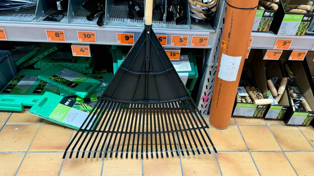 Laubbesen-Test: Detailansicht der Kehreinheit eines Besens, der vor einem Verkaufsregal mit anderen Produkten steht.