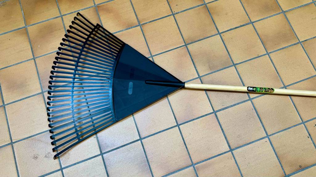 Ein Laubbesen liegt zum testen auf einem Fliesenboden.