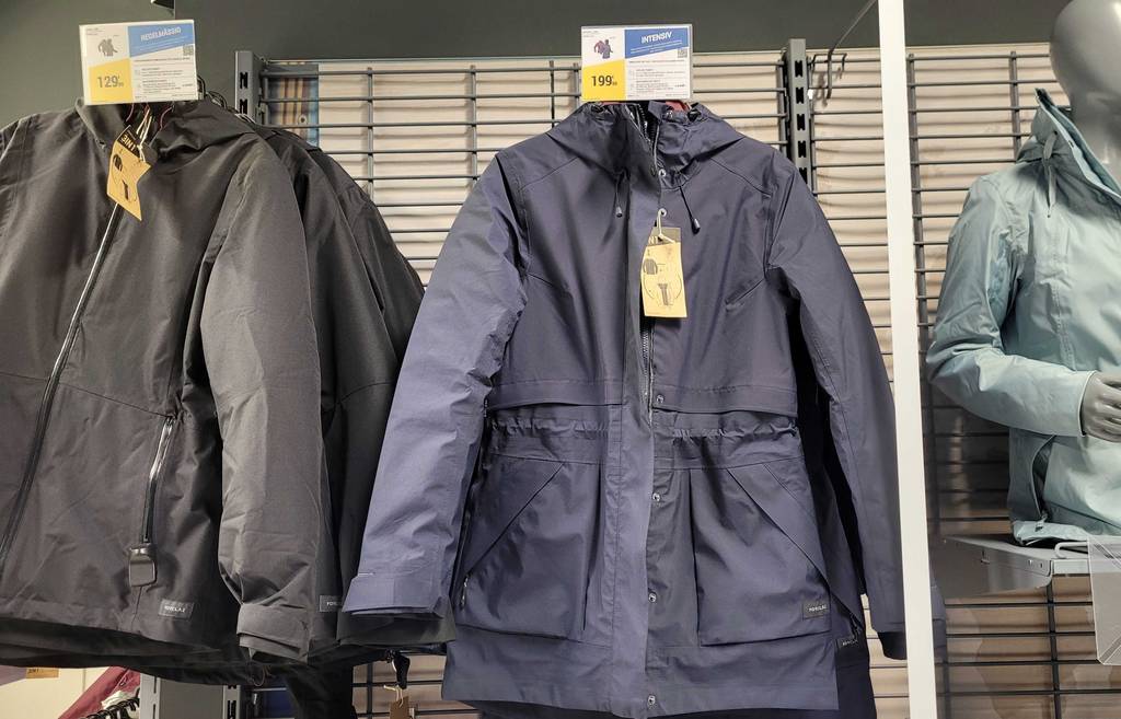 3-in-1-Jacke im Test: zwei Jacken-Modelle in Schwarz und Blau hängen in einem Verkaufsbereich.