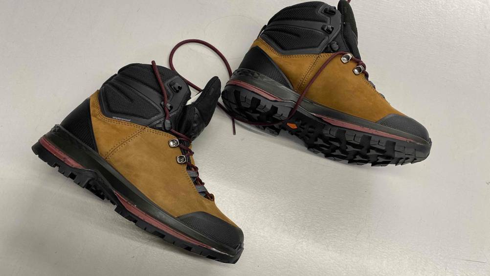 Im Test: Forclaz Trekkingschuhe für Damen in ocker-schwarz liegen seitlich auf weißer Fläche.
