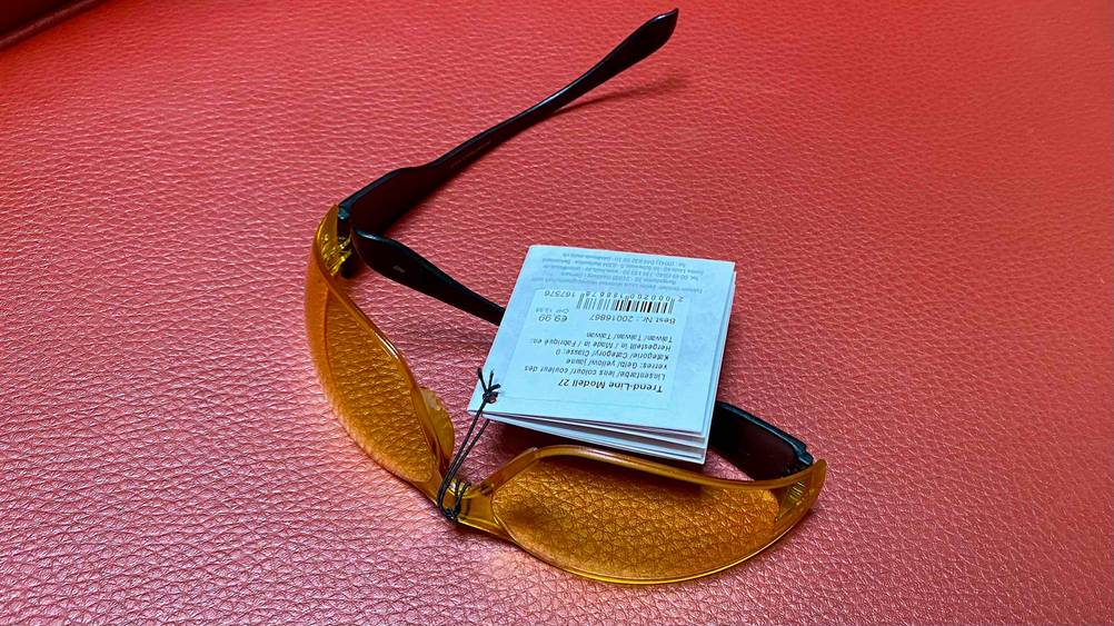 Motorradbrille getestet: Eine Brille mit einem aufgeklappten Bügel auf einer roten Fläche.