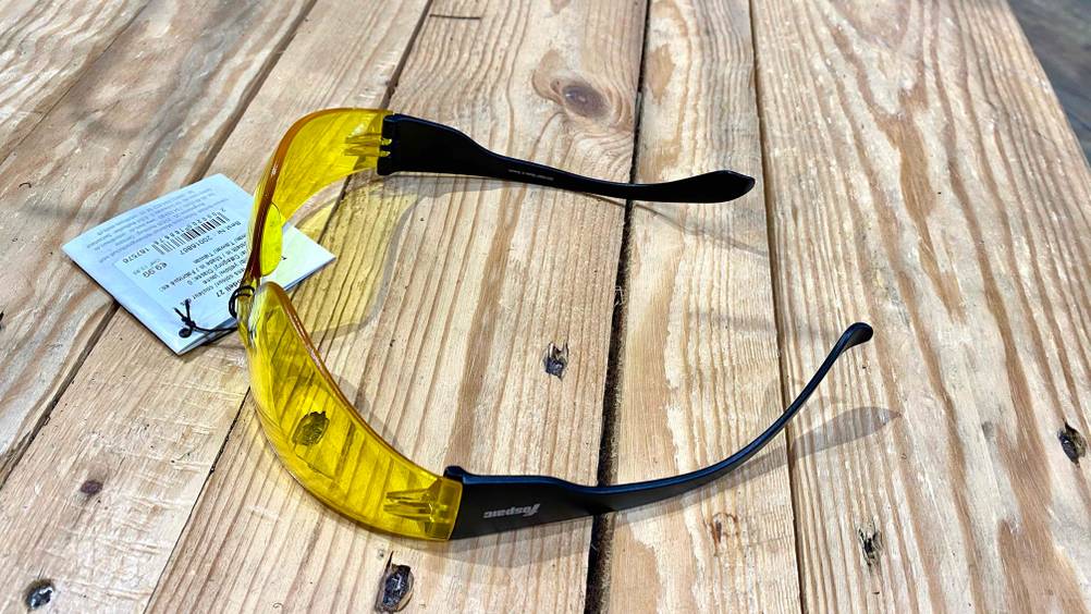 Eine Motorradbrille im Test aufgeklappt von der Seite auf einem Holztisch.