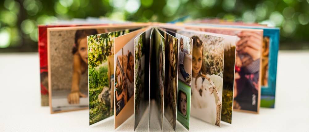 Fotobuch mit gestalteten Seiten und verschiedenen gedruckten Erinnerungsfotos.