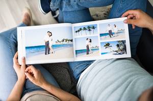 Fotobuch im Test: Ein gedrucktes Fotobuch liegt auf dem Schoß eines Mannes