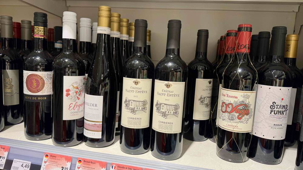 Mehrere Flaschen der getesteten französischen Weine in eine Verkaufsregal.