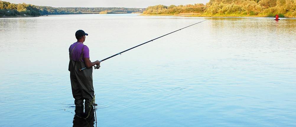 angler mit freilaufrolle im see