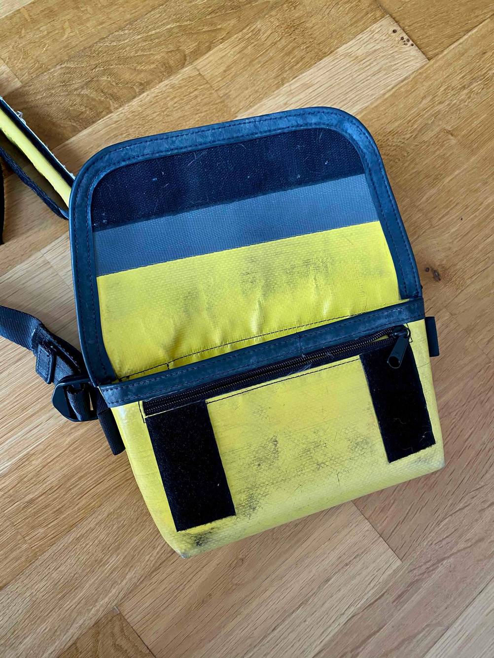 Im Test: Eine Bauchtasche mit geöffneter Klappe liegt auf einer Holzfläche.