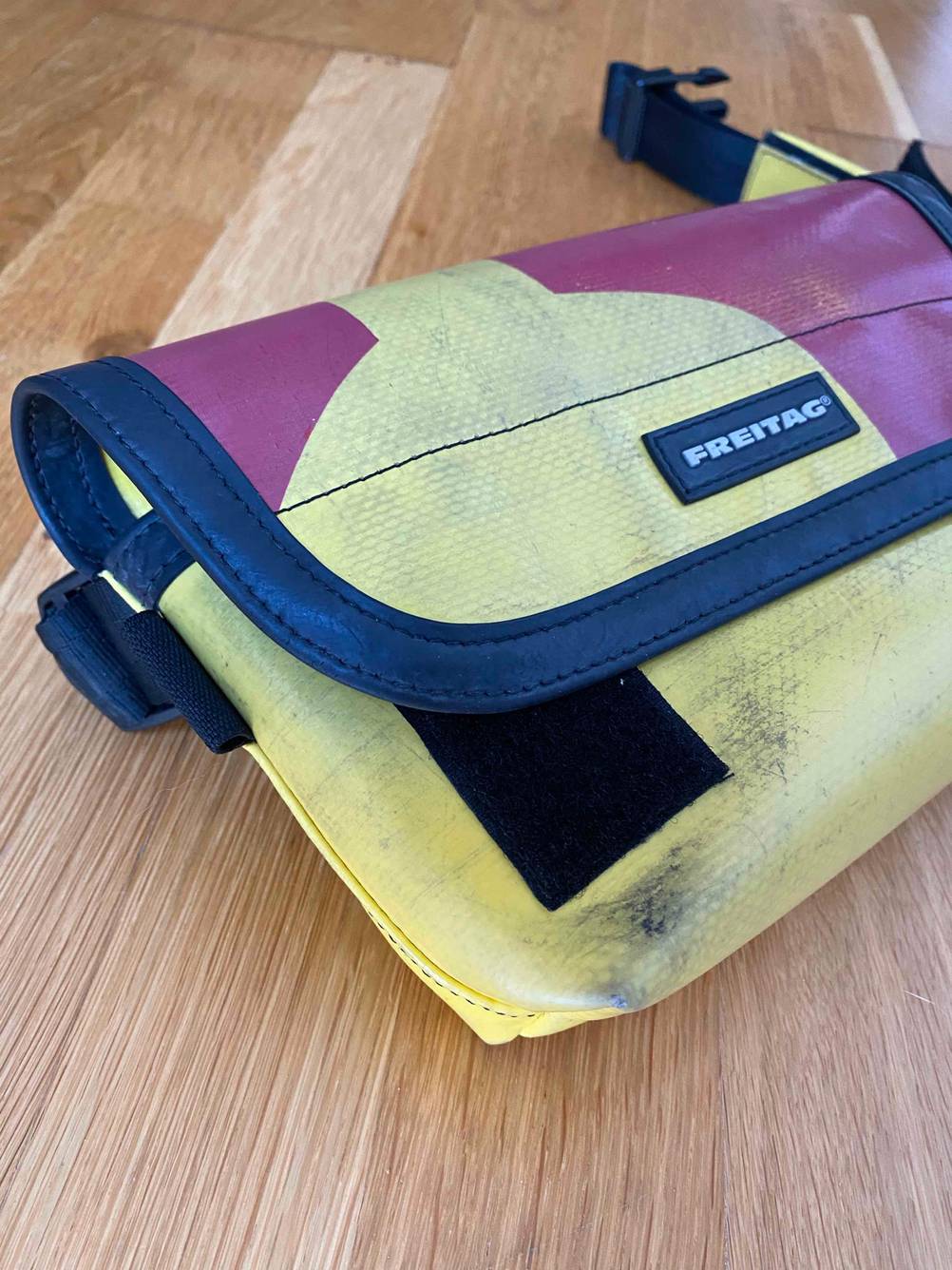 Nahaufnahme des Klettverschlusses einer getesteten Bauchtasche auf einer Holzfläche.