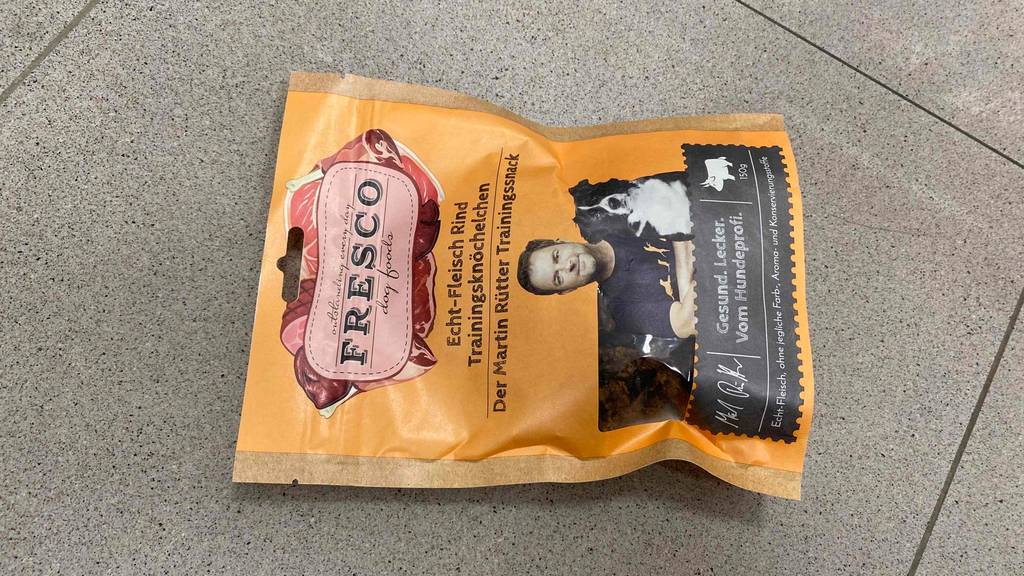 Auf dem Boden befindet sich eine Packung getestetes Fresco-Hundefutter. 