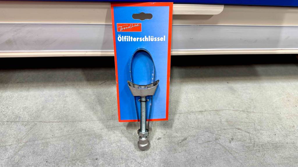 Der getestete Ölfilterschlüssel befindet sich auf eseiner blauen Verkaufspappe auf dem Boden.
