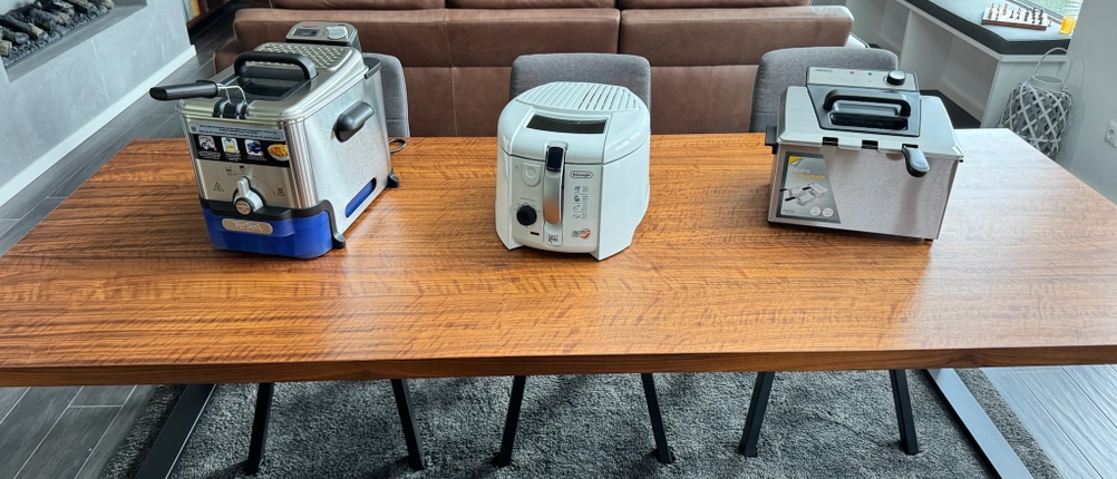 Drei Fritteusen stehen nebeneinander auf dem Tisch.