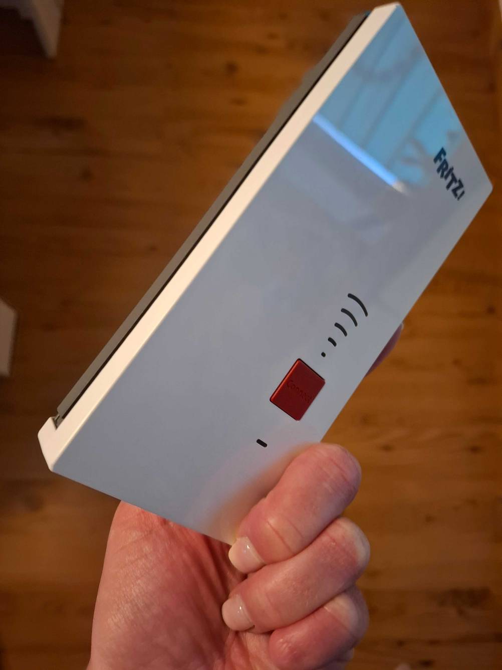 Eine Hand hält einen Fritz-Repeater zum testen.