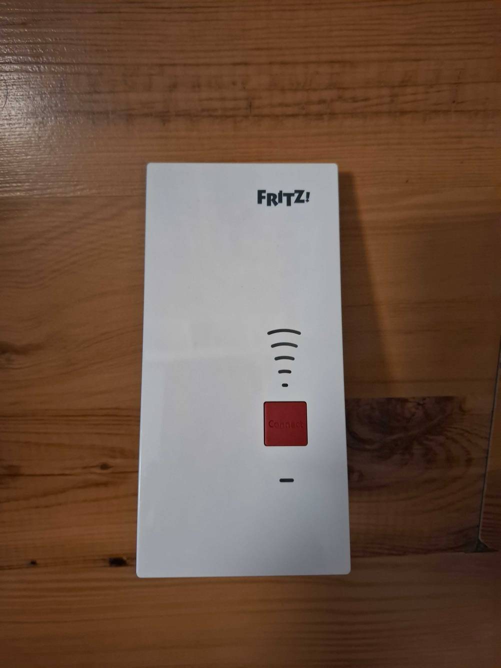 Ein Fritz-Repeater liegt zum testen auf einer Holzfläche.