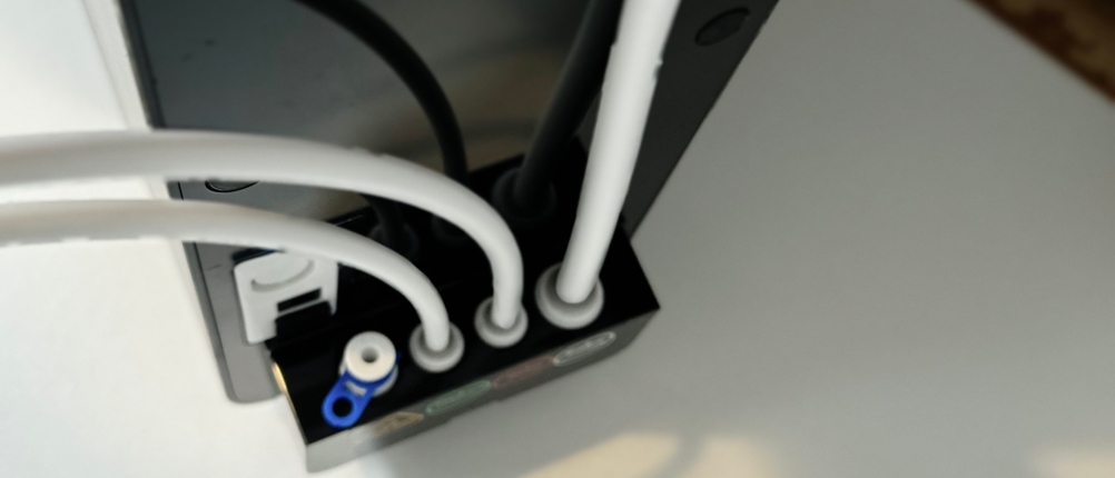 Zu sehen ist die Rückseite der Frizzlife PD1000-TAM4 mit farblich markierten Schlauchanschlüssen. Die Schläuche sind bereits eingesteckt.