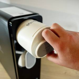 Der Filter der Frizzlife wird nach unten von einer Hand herausgezogen.