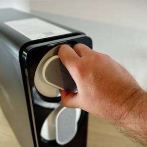 Auf dem Foto ist eine Hand zu sehen, die den Filtereinsatz der Frizzlife PD1000-TAM4 nach links dreht. Der Mechanismus wird gerade gelöst.