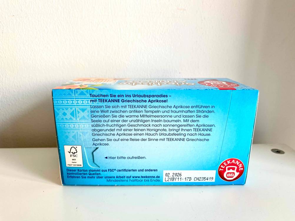 Unterseite einer Packung getesteten Früchtetees vor einer hellen Wand.