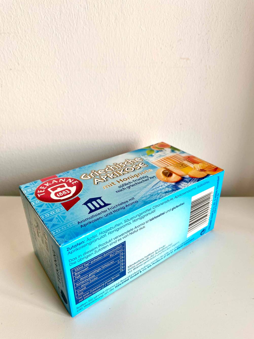 Seitenansicht einer Packung des getesteten Früchtetees auf einer hellen Fläche.