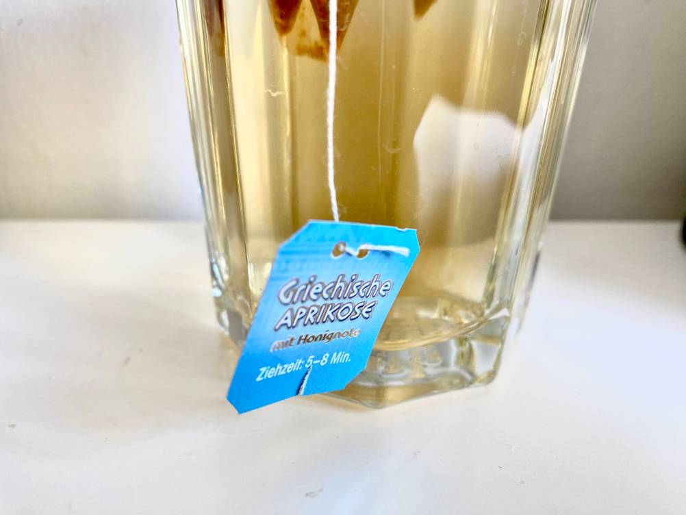 Früchtetee getestet: Nahaufnahme des Etiketts eines Teebeutels der aus einem Glas hängt.