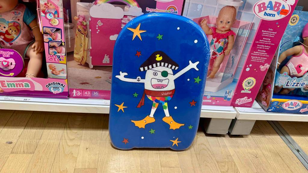 Ein Bodyboard für Kinder steht zum testen vor einem Regal mit Spielwaren.