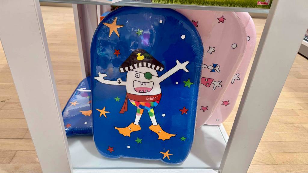 Bodyboard für Kinder im Test: Mehrere Boards in verschiedenen Designs stehen und liegen in einem Regal.