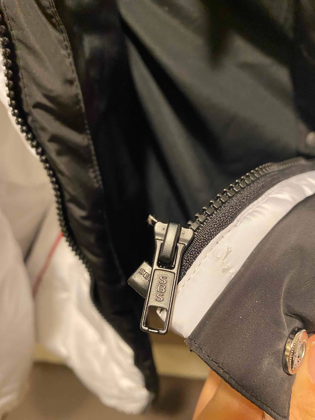 Detailansicht des Reißverschlusses einer getesteten Daunenjacke für Herren.