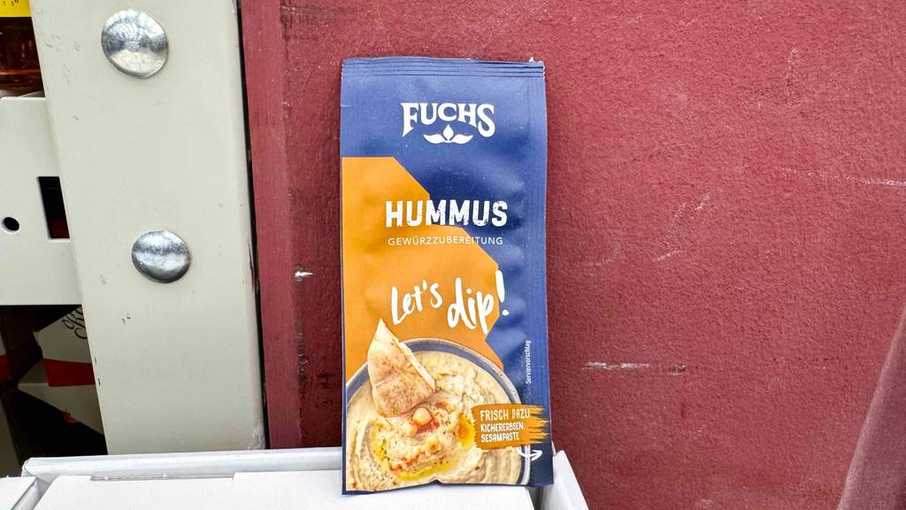 Fuchs-Gewürze im Test: Eine Packung der Sorte Hummus steht vor einer roten Wand.