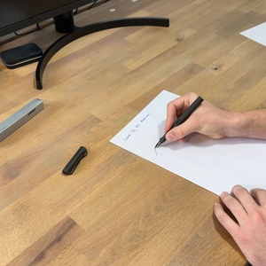 Mit dem Lamy-Füller wird auf ein Blatt geschrieben.