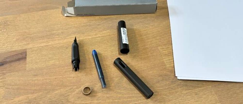 Der Lieferumfang des Lamy Safari Umbra liegt auf einem Schreibtisch.