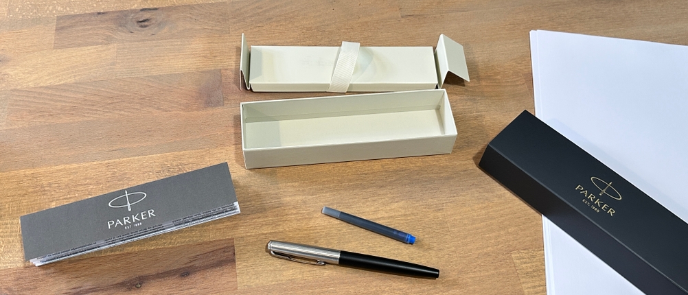 Der Lieferumfang des Parker-Füllers liegt auf einem Schreibtisch.