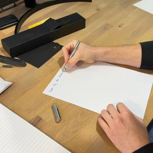 Mit dem Scriveiner-Füller wird auf ein Blatt Papier geschrieben.