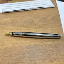 Der Scriveiner-Füller liegt ohne Kappe auf einem Schreibtisch.