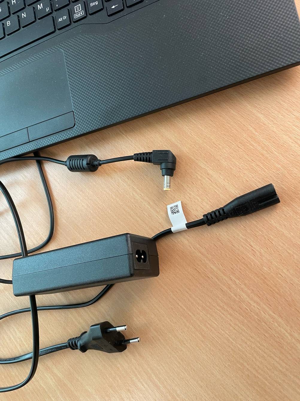 Vor einem getesteten Fujitsu-Lifebook liegt das mehrteilige Netzteil.