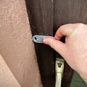 Die Halterung des Senders der Honeywell-Funkklingel wird an einem Türrahmen angebracht.