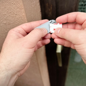 Am Sender der Honeywell-Funkklingel wird ein doppelseitiges Klebeband angebracht.