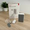 Auf einem Tisch ist der Lieferumfang der Honeywell-Funkklingel ausgebreitet.