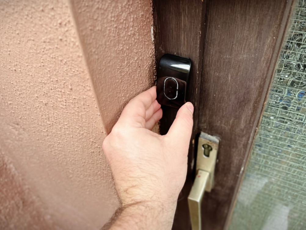 Der Sender der Funkklingel von Tecknet wird an einem Türrahmen befestigt.