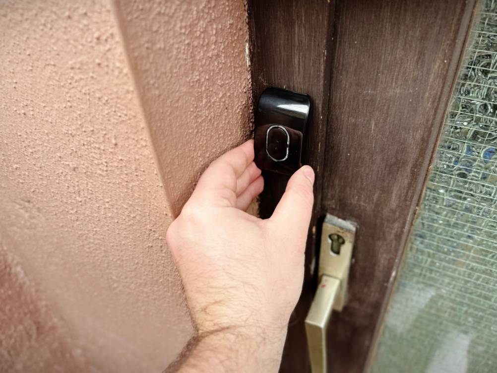 Der Sender der Funkklingel von Tecknet wird an einem Türrahmen befestigt.