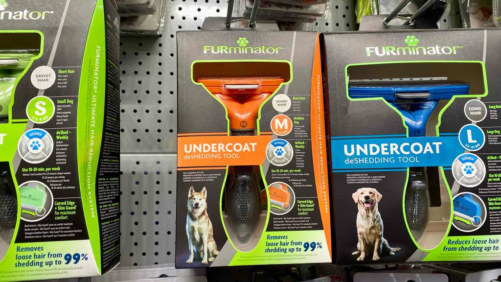 Mehrere verpackte Hundescheren im Test hängen an einem Verkaufsregal.