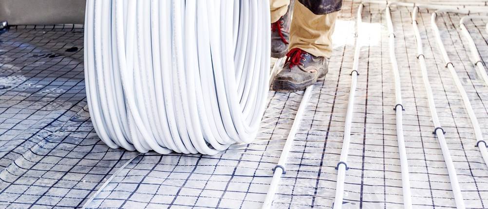 Handwerker installieren eine Fußbodenheizung.