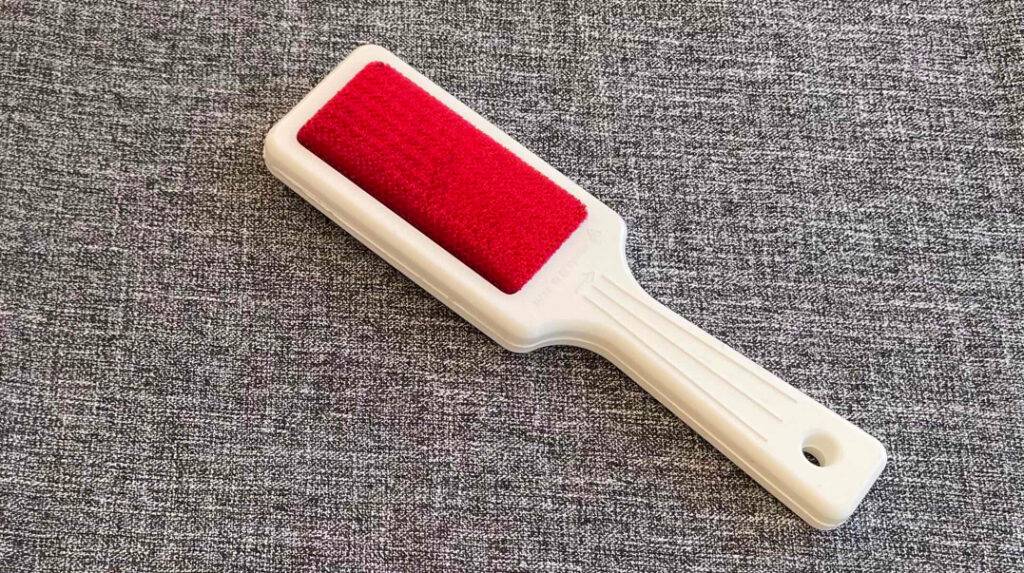 Im Test: Fusselbürste liegt auf grauem Stoff.