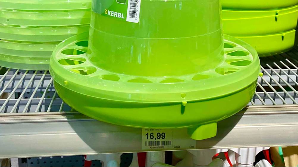 Nahaufnahme der Futterschale und der Löcher eines getesteten Hühner-Futterautomaten mit Preisangaben.