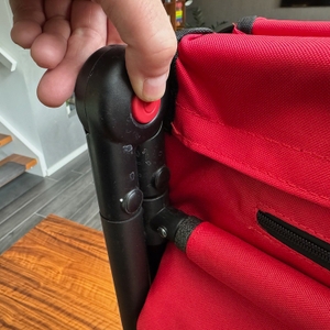 Eine Hand drückt den Knopf zum Entriegeln des Fuxtec FX-CT700 im zusammengeklapptem Zustand.