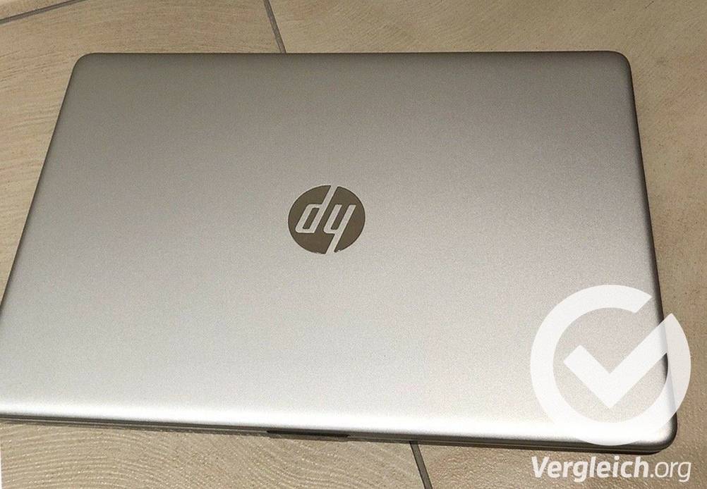 Ein silberner geschlossener getesteter Laptop steht auf Fliesen.