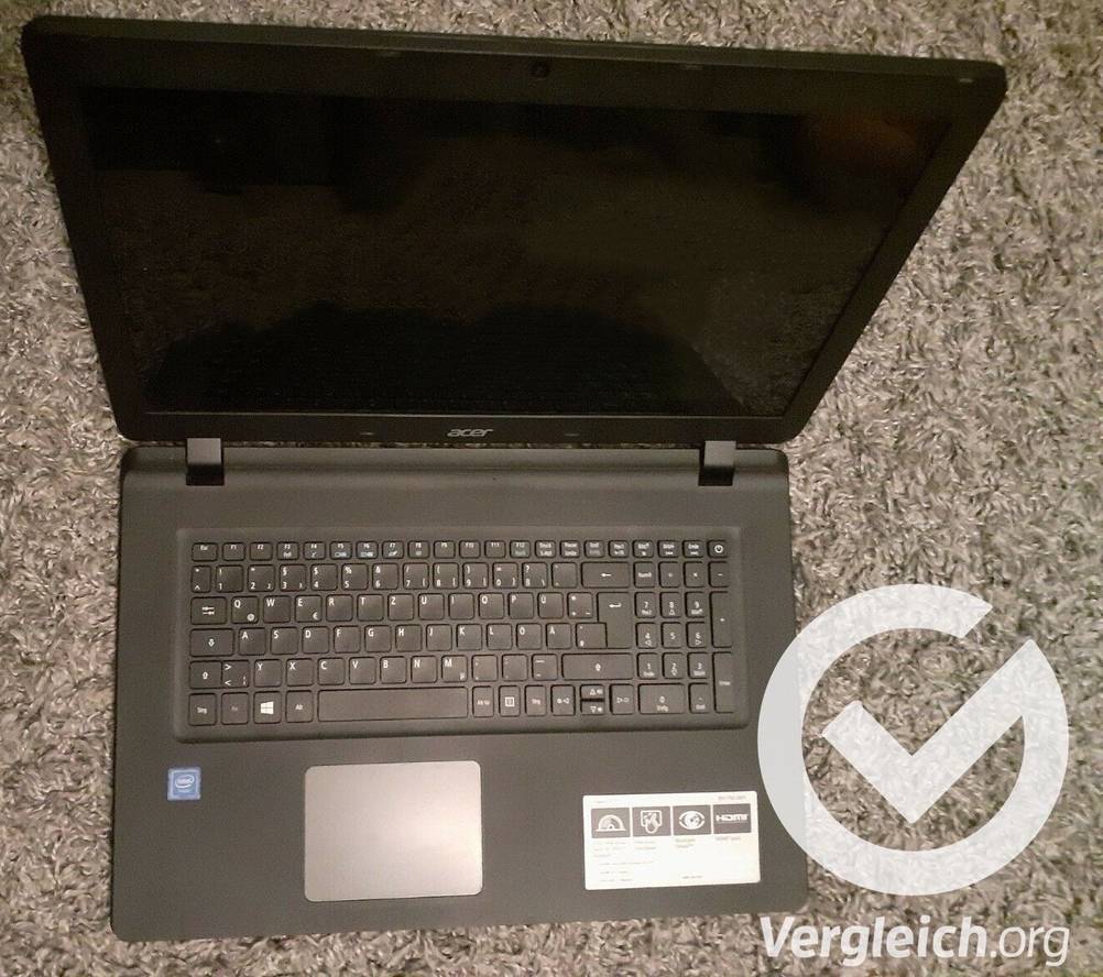 Ein getesteter schwarzer Laptop steht auf einem Teppich.